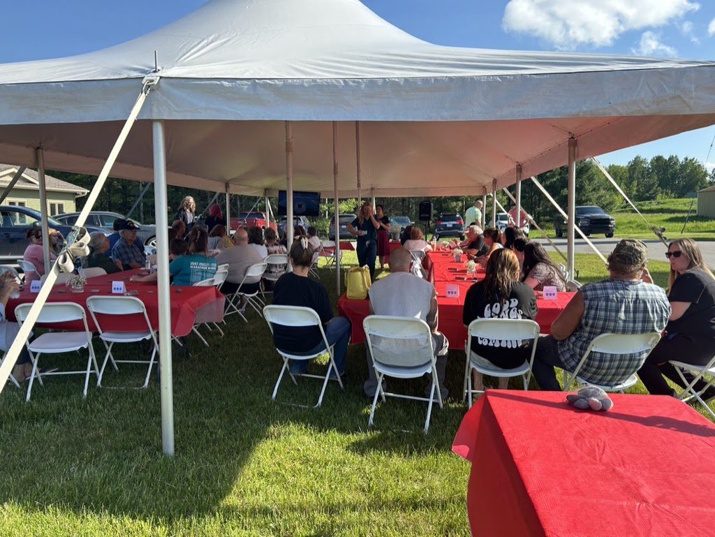 People sitting under a canopy tent