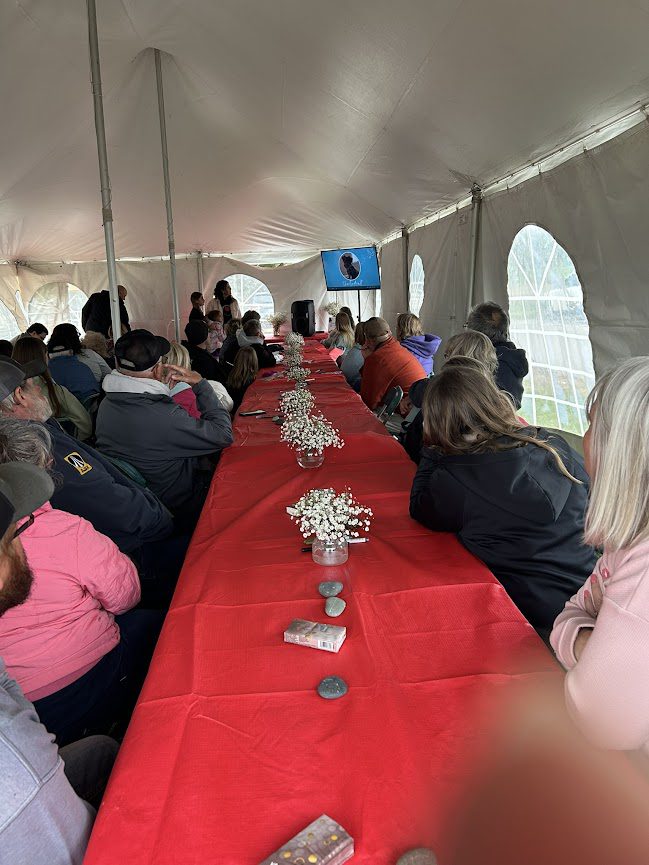 People sitting at long rectangular tables with red tablecloths