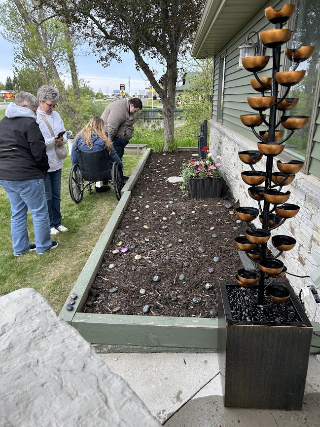 People looking at area with mulch and memorial stones
